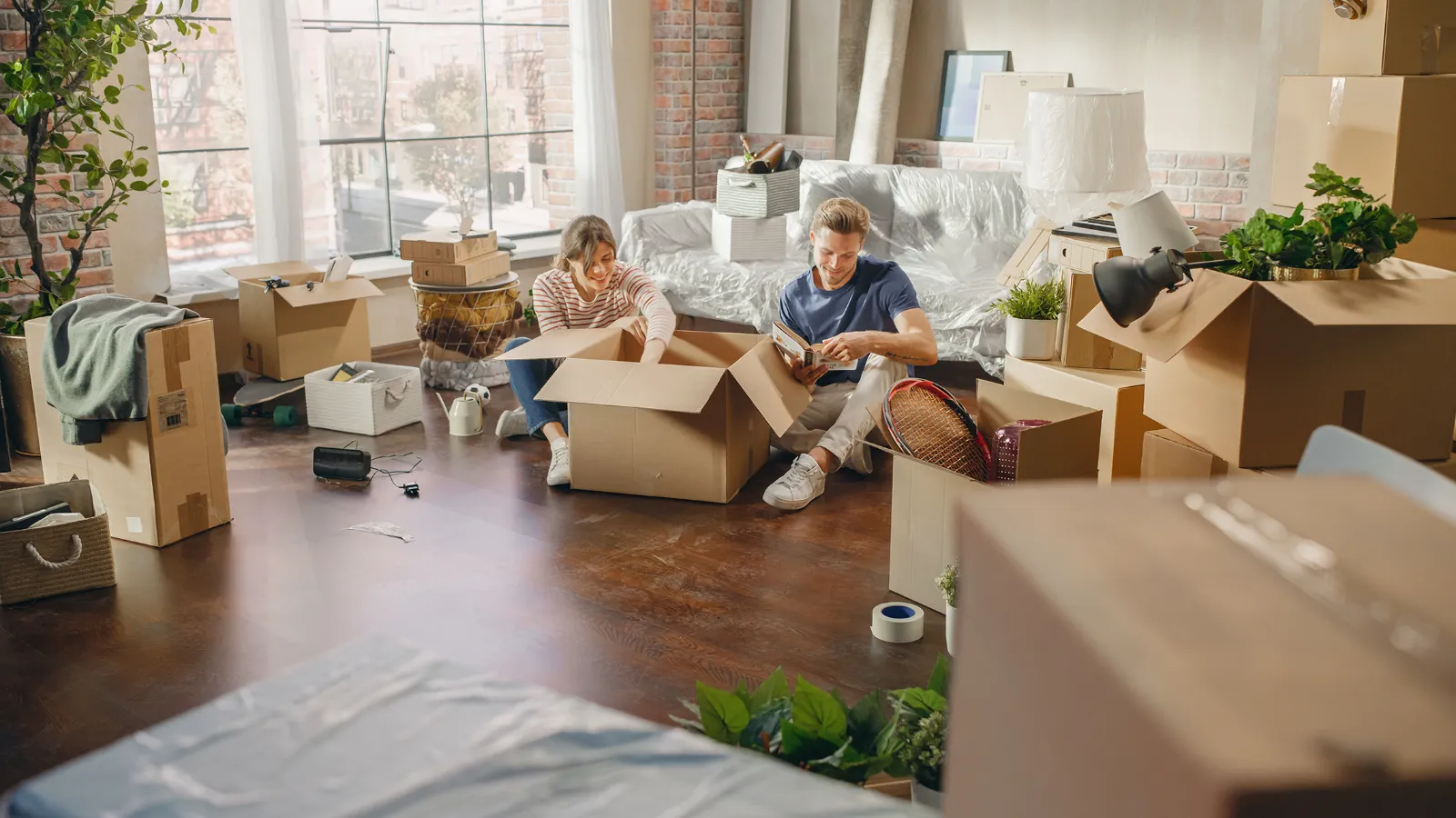 Paar packt Umzugskartons in der neuen Wohnung